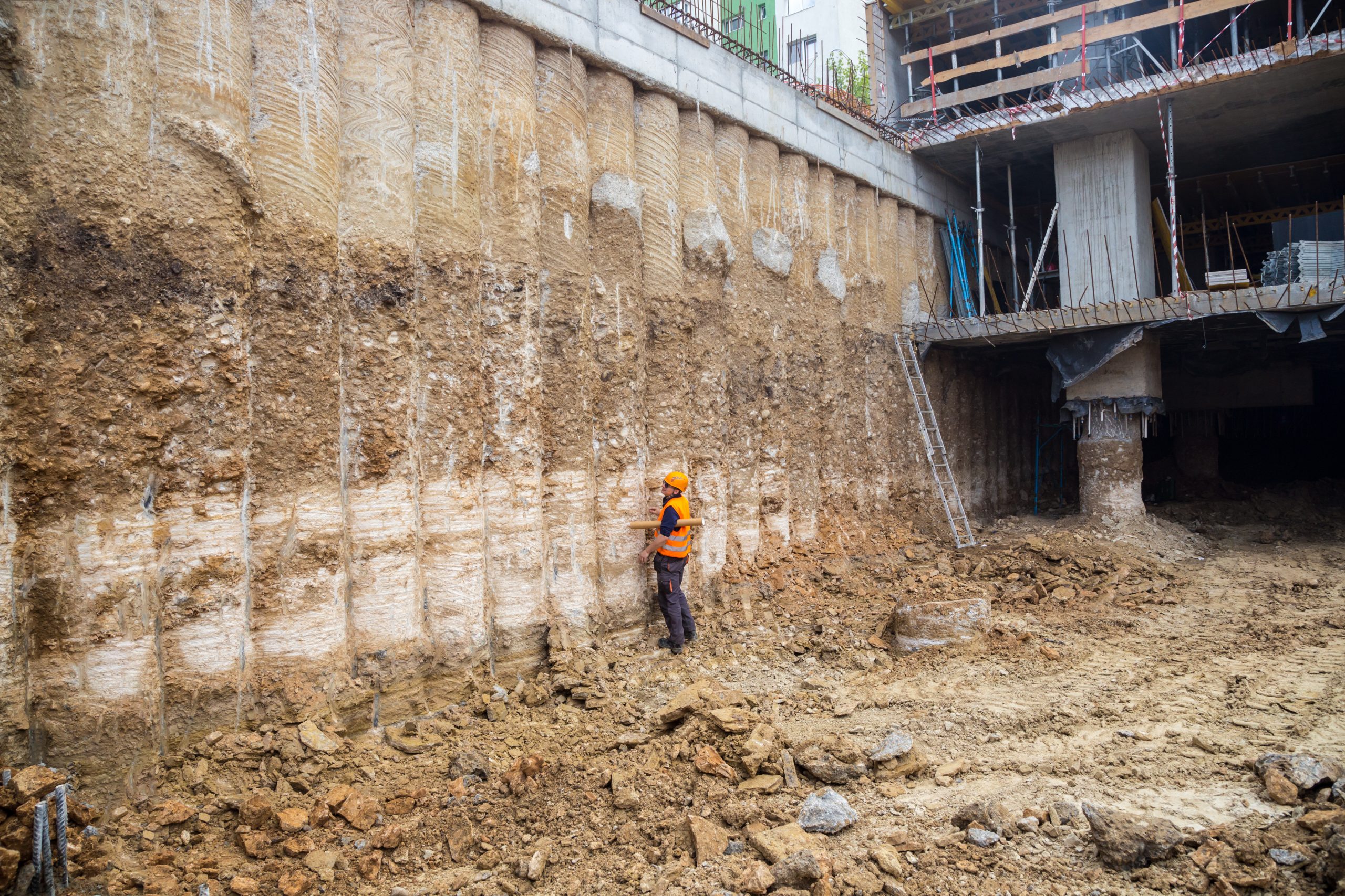 Construction worker checking pile retaining wall